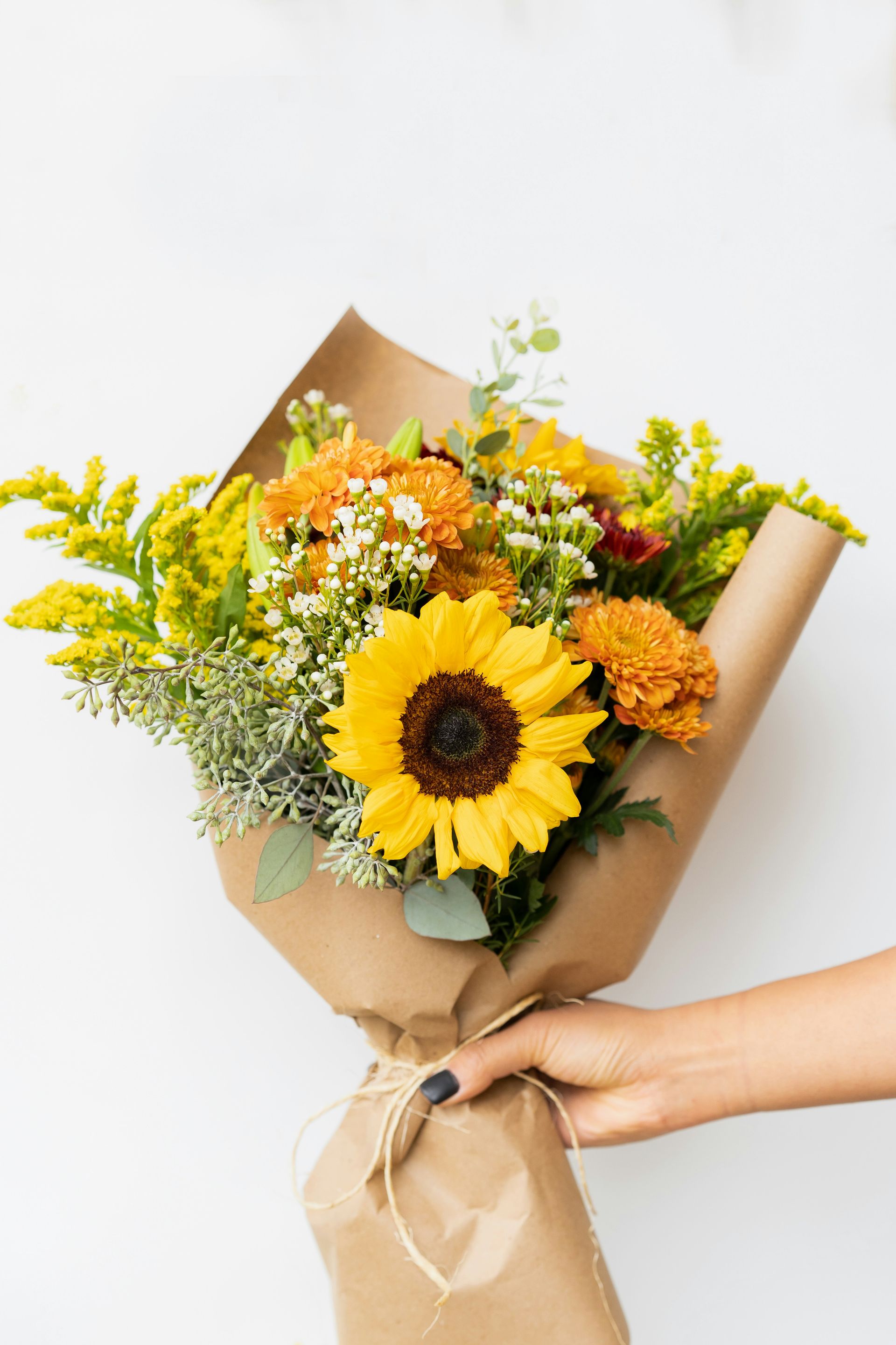 person holding yellow sunflower bouquet